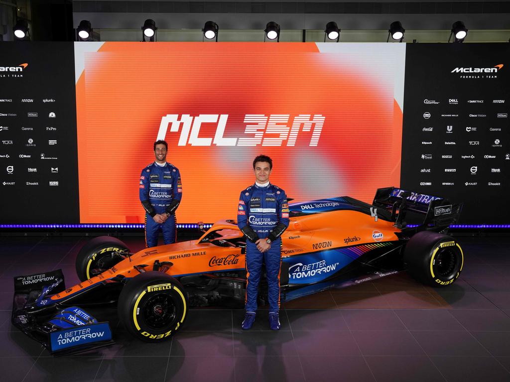 Lando Norris and Daniel Ricciardo posing by the new McLaren Formula 1 car MCL35M in Woking, southwest of London. (Photo by Handout / McLAREN / AFP)