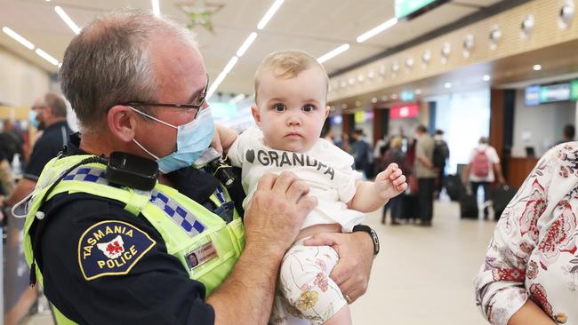 Tasmania Police Senior Constable Paul Edwards who was working at the airport on day 1 of border reopening reunited with granddaughter Isla 7 months from Newcastle who have been separated since she was 4 weeks old. Picture: Nikki Davis-Jones