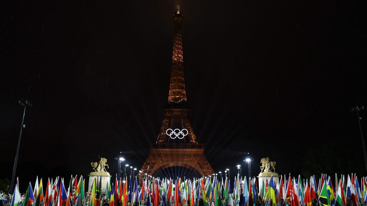 Flags of participating countries are carried during the opening ceremony. (Photo by Stephanie Lecocq / POOL / AFP)