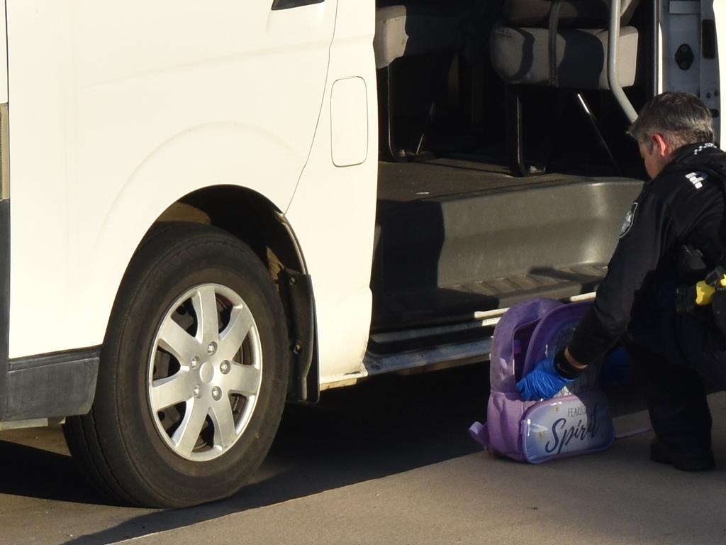 Police inspecting a bag at a child care centre where a three-year-old was discovered left inside the bus on May 4, 2022.