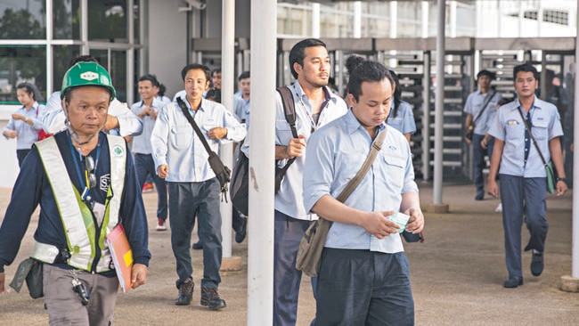 Ford workers leave the manufacturing plant, outside of Bangkok, after their shift. Picture: Patrick Brown.