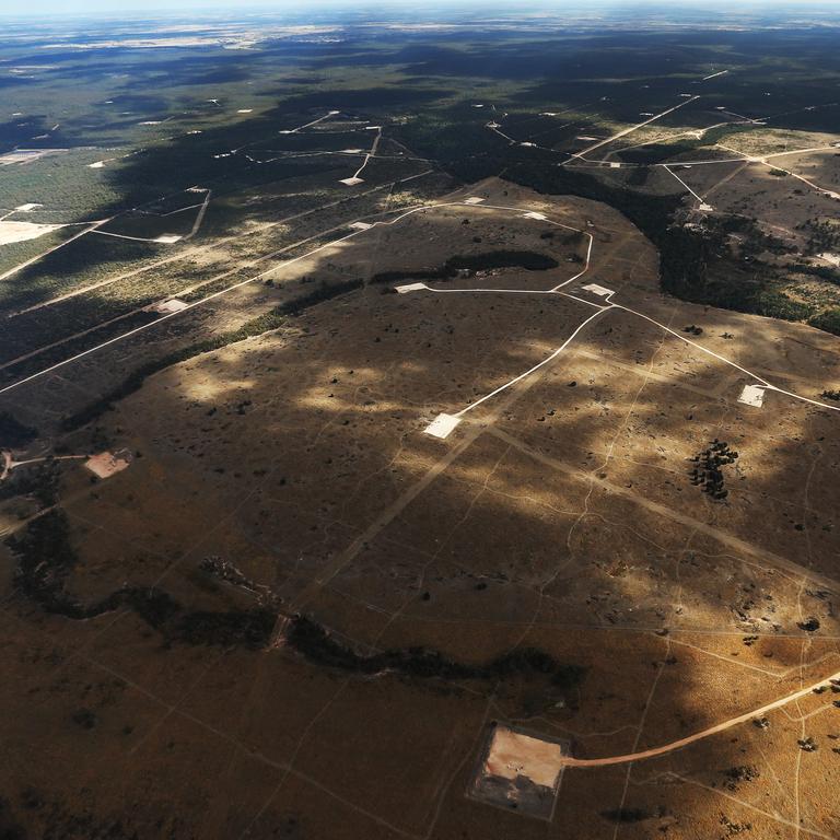 Gas wells, gas well pads, pipelines and easements stretch off into the distance in the QGC Kenyan gas fields near the Condamine State Forrest, north of Tara. Picture: NewsCorp