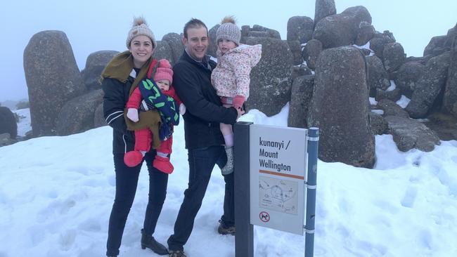 Kym Nissen with Doug, Eve and Olive Izatt. After the road to the top of Mt Wellington was cleared hundreds of locals hit the snow.