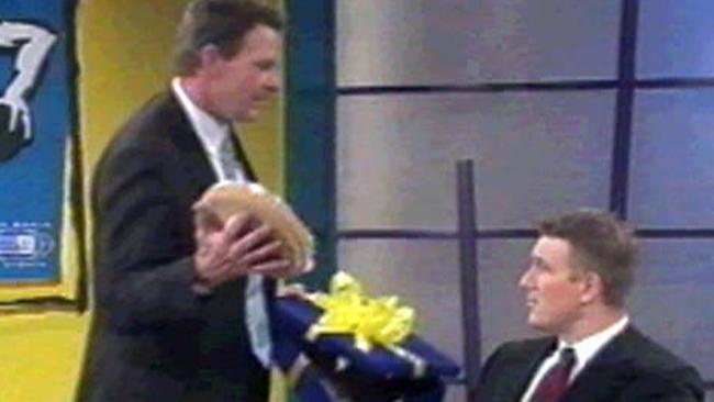 Sam Newman prepares to pie an unsuspecting David Schwarz in the face.