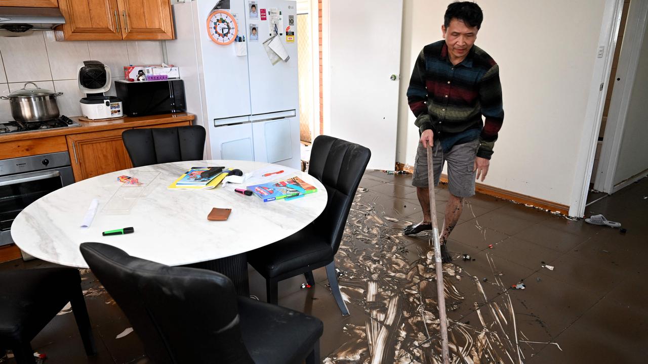 A man clears mud from his kitchen in a flood-hit Maribyrnong home. Picture: AFP