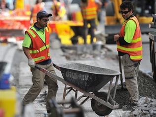 Construction workers perform roadworks in Melbourne