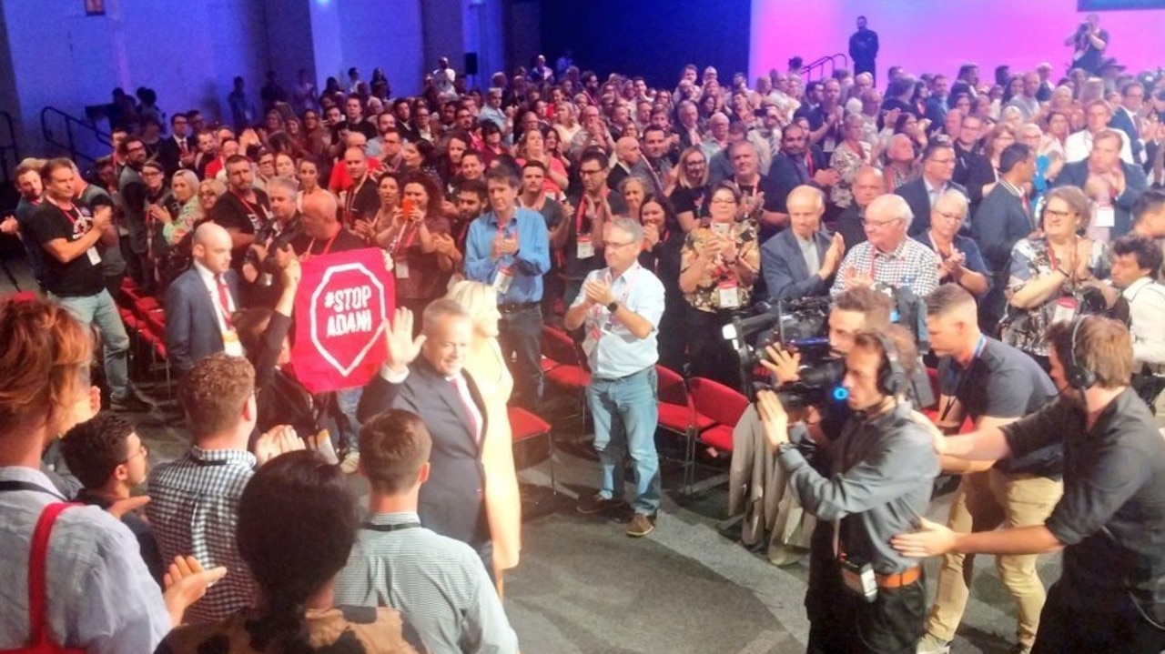 The Adani protesters shadowing Bill Shorten with a sign. 