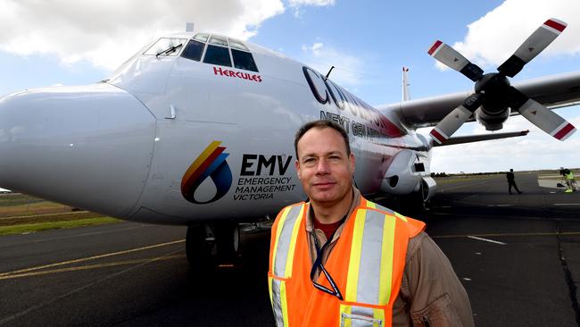 Pilot Travis Adams with one of Victoria's waterbombing air contingent, a C-130 Hercules. Picture: MIKE KEATING