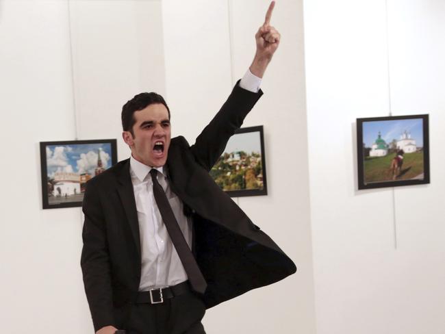 FILE - In this Monday, Dec. 19, 2016 file photo Mevlut Mert Altintas shouts after shooting Andrei Karlov, right, the Russian ambassador to Turkey, at an art gallery in Ankara, Turkey. Associated Press photographer Burhan Ozbilici won the 2017 World Press Photo competition Monday Feb. 13, 2017 for the image. It was part of a series titled "An Assassination in Turkey" which also won the Spot News - Stories category, captured in the moments before and after Altintas, an off-duty policeman, drew a handgun and shot Karlov at a photo exhibition. (AP Photo/Burhan Ozbilici, File)