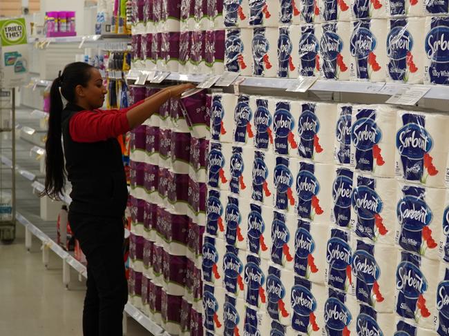 A Coles worker putting the final touches on restocking toilet paper. Picture: Coles