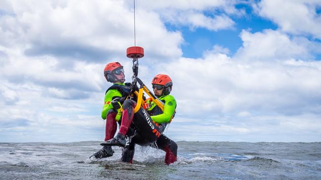 Liam O'Callaghan is winched out of the water while rescuing Alex Schwarcz. Picture: Jake Nowakowski