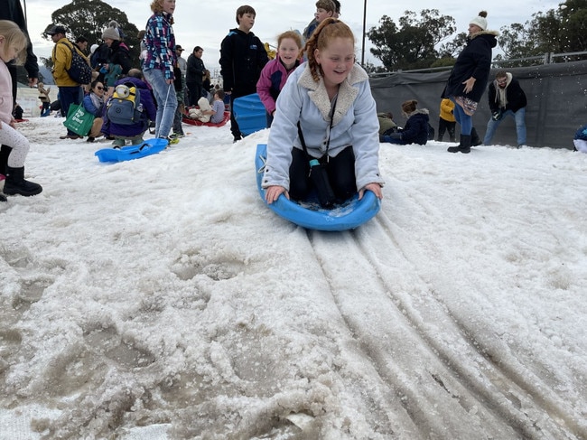 10-year-old Lilly Dennis from Warwick sliding down the snow hill on the toboggan at the Snowflakes in Stanthorpe 2021 festival. Photo: Madison Mifsud-Ure / Stanthorpe Border Post