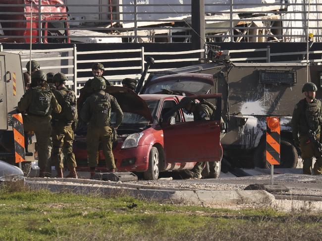 Israeli security forces surround a car which was allegedly used by a Palestinian to ram into Israeli soldiers at the entrance of al-Fawwar refugee camp. Picture: AFP