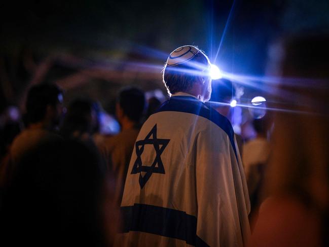 A man wearing Israeli flag takes part in a vigil for the Israeli victims in Lisbon. Picture: AFP