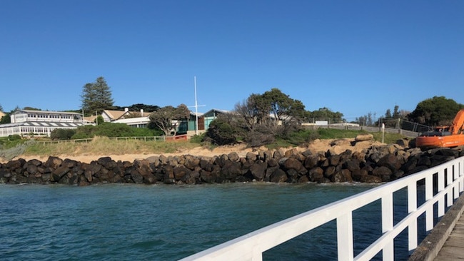 The temporary rock wall erected to protect workers replacing sandbags along Portsea beach.