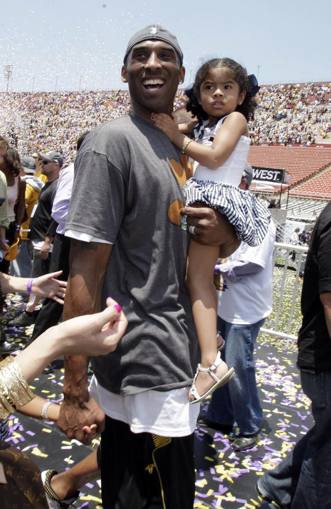 Los Angeles Lakers' Kobe Bryant smiles as he and his daughter Gianna Maria-Onore walk up the steps after the victory parade celebrating the Lakers' NBA championship in Los Angeles on June 17, 2009. Picture: Getty