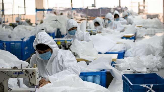 Chinese workers sewing at factory making hazardous material suits to be used in the COVID-19 coronavirus outbreak. Picture: AFP