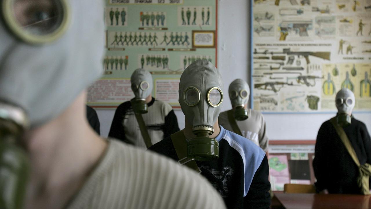 Ukrainian students try on gas masks as part of a safety drill in a school in Rudniya, just outside the Chernobyl contamination zone in 2006. Picture: Oded Balilty/AP