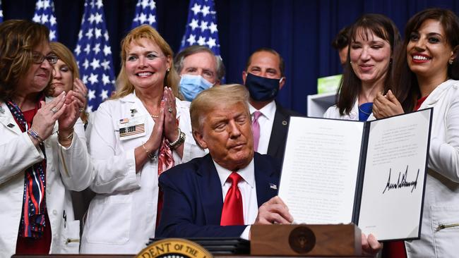 Donald Trump signs an executive order lowering drug prices. Picture: AFP