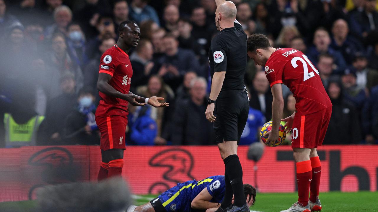 Referee Anthony Taylor shows a yellow card to Liverpool’s striker Sadio Mane. (Photo by Adrian DENNIS / AFP)