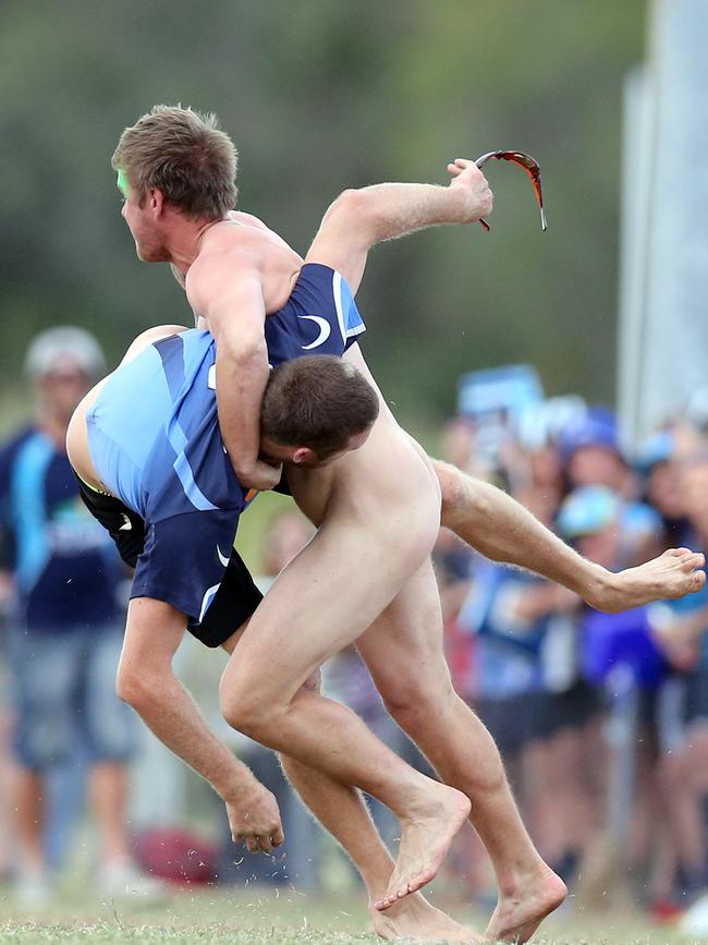 Photos at the Gold Coast and District Rugby Union Grand Final between the Gold Coast Eagles and the Helensvale Hogs (blue) played at Helensvale. Photo of a streaker wearing the Gators mascot's head. The tackler became the tackled. Photo by Richard Gosling