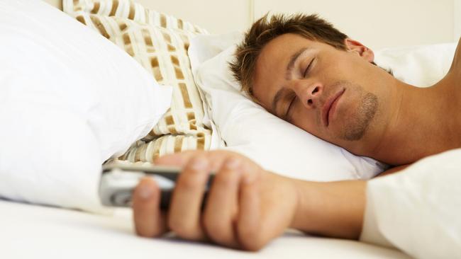 Sleeping Man Holding Cell Phone THINKSTOCK IMAGE