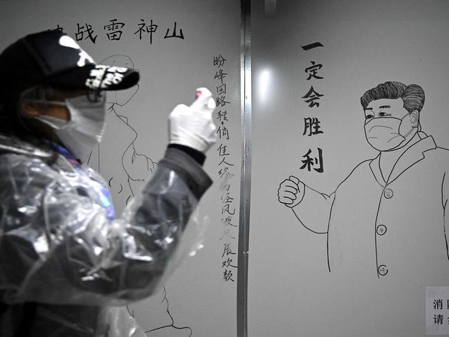 A man walks in front of a drawing of Chinese President Xi Jinping on a wall at the Leishenshan Hospital in Wuhan. Picture: AFP