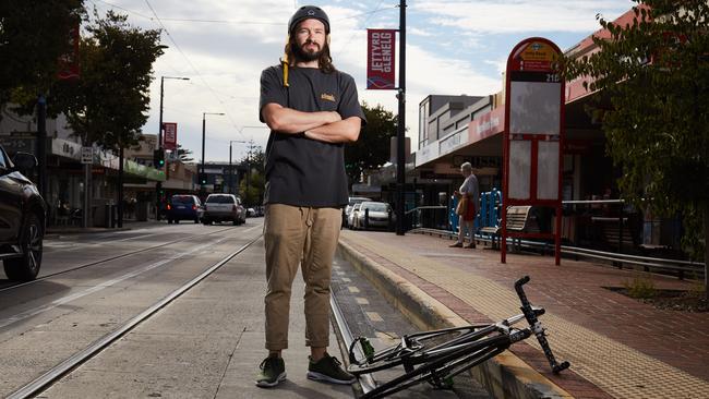 Cyclist Gareth Williams in front of stop 16 on Jetty Rd, where bikes regularly get their wheels stuck in the tram-track grooves. Picture: Matt Loxton.