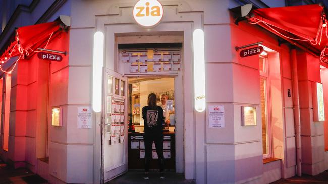 A woman orders a takeaway pizza at a restaurant in Berlin. Picture: AP