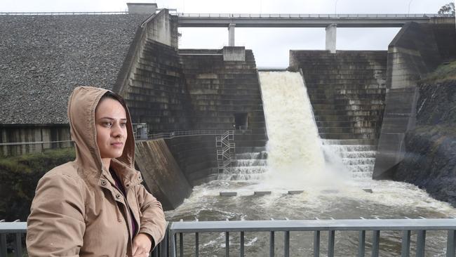 Paigan Price from Upper Coomera watches floodwaters from the wild weather pour over the spillway at the Hinze Dam. Picture Glenn Hampson Picture Glenn Hampson.