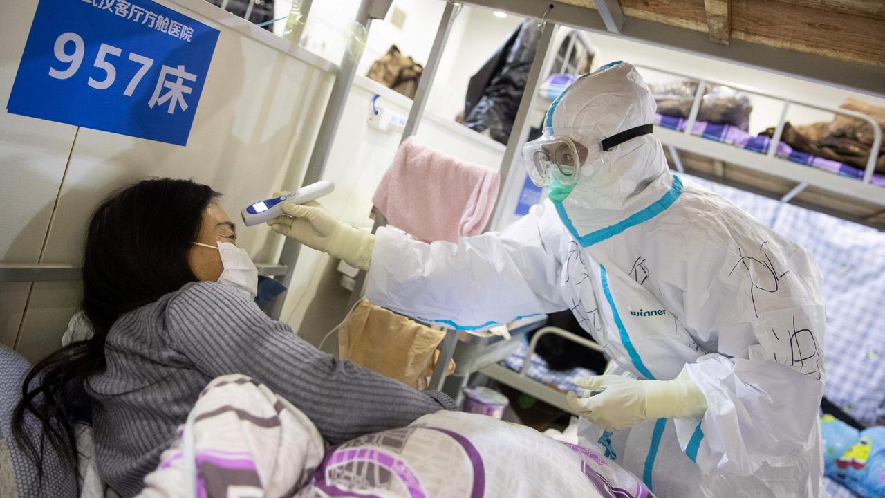 A patient has her temperature checked at an exhibition centre converted into a hospital in Wuhan on Monday, February 17, 2020. Picture: AFP