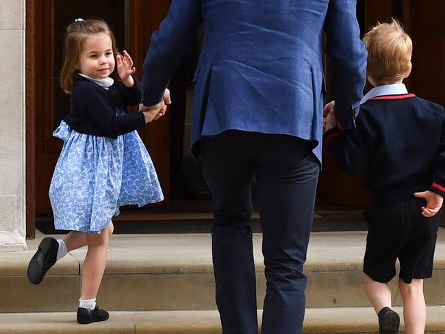 Princess Charlotte turns to wave at the media as she and her brother Prince George are led into the hospital by their father. Picture: AFP Photo / Ben Stansall