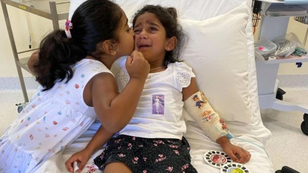 Tharnicaa with her sister Kopika in hospital on Christmas Island the day before an emergency evacuation to Perth. Picture: Supplied