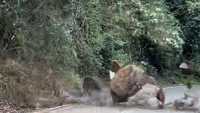 Boulders tumble on to the road.