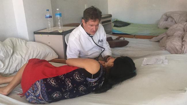 Dr Ray Hodgson working with a female patient in Nepal where 25-35 per cent of women suffer genital prolapse.