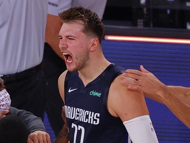 LAKE BUENA VISTA, FLORIDA - AUGUST 23: Luka Doncic #77 of the Dallas Mavericks celebrates a game winning three point basket with teammates against the LA Clippers during overtime in Game Four of the Western Conference First Round during the 2020 NBA Playoffs at AdventHealth Arena at ESPN Wide World Of Sports Complex on August 23, 2020 in Lake Buena Vista, Florida. NOTE TO USER: User expressly acknowledges and agrees that, by downloading and or using this photograph, User is consenting to the terms and conditions of the Getty Images License Agreement.  (Photo by Kevin C. Cox/Getty Images)