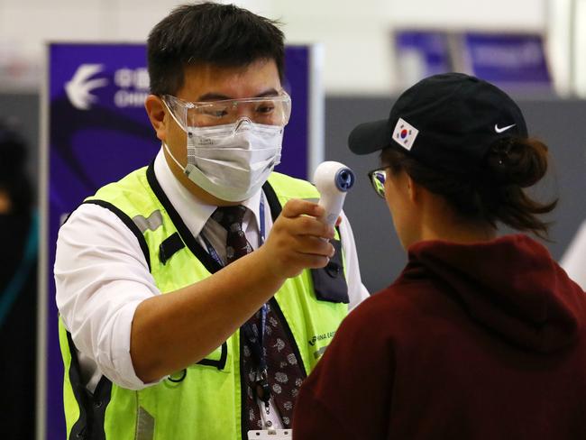 Passengers arriving and departing at Sydney International Airport take precautions by donning a variety of face masks. Picture: Matrix