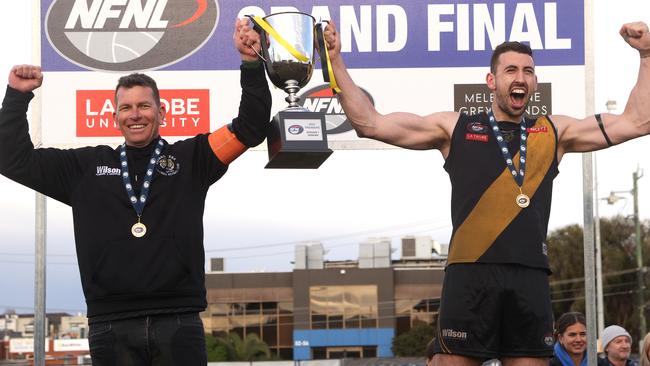 Heidelberg coach Danny Nolan and captain Sam Gilmore lift the premiership cup. Picture: Hamish Blair