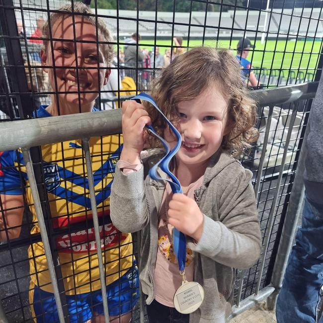 Brooke Anderson giving away her City v Country medal to young fan, Maeve Brown.