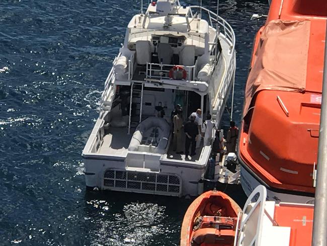 A man believed to be the ship's captain boards a police boat at Eden after the 10-day Carnival Legend cruise had passengers reportedly involved in violent clashes and disruptive behaviour. Picture: Supplied