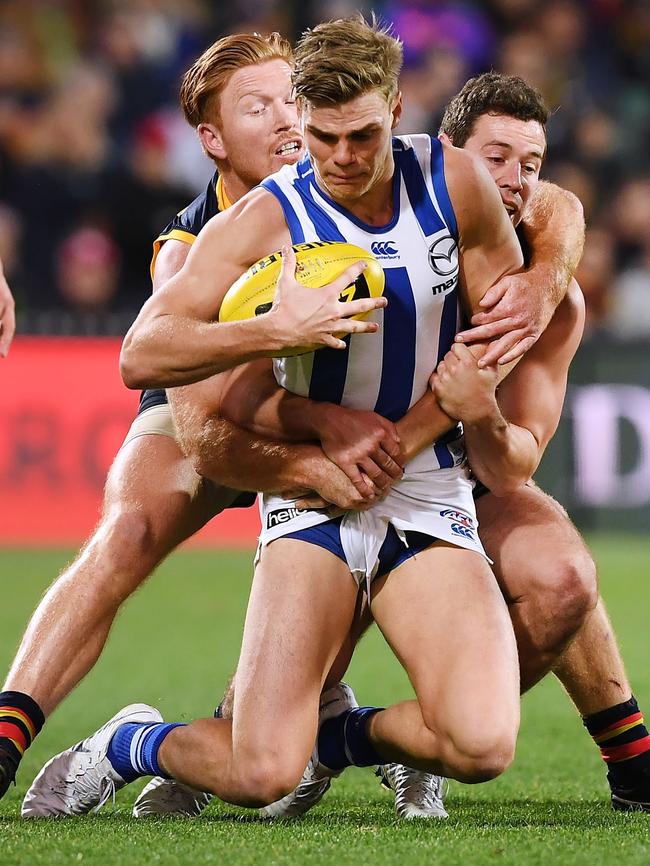 Mason Wood of the Kangaroos gets caught holding the ball by Kyle Cheney and Luke Brown. Picture: Mark Brake/Getty Images