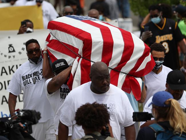 People carry an empty symbolic casket draped with an American flag during a Juneteenth march and celebration in Tulsa, Oklahoma. Picture: Getty