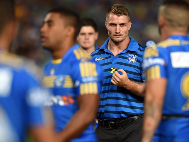 Injured Eels halfback Kieran Foran (centre) watches his teammates warm up before the start of their round 1 NRL match between the Parramatta Eels and the Brisbane Broncos at Pirtek Stadium in Sydney on Thursday, March 3, 2016. (AAP Image/Paul Miller) NO ARCHIVING, EDITORIAL USE ONLY