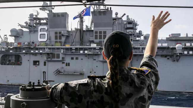 The Commanding Officer of HMAS Parramatta, Commander Anita Nemarich, waves at USS America during officer of the watch manoeuvres in the South China Sea. Picture: Department of Defence