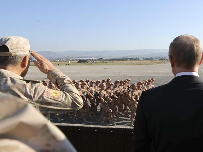 Russian President Vladimir Putin, right, watches the troops marching as he and Syrian President Bashar Assad visit the Hemeimeem air base in Syria. Private Russian military contractors were killed by a US strike in Syria, Russian media reports. Picture: AP