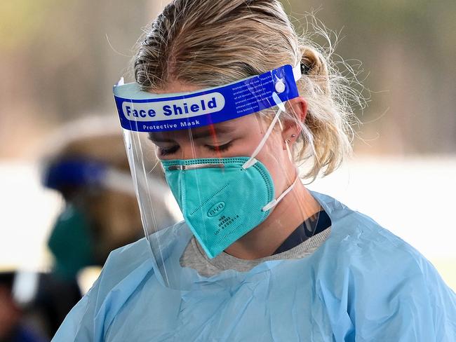 SYDNEY, AUSTRALIA - NewsWire Photos JULY, 07, 2021: Health workers dressed in Personal Protection Equipment (PPE) collect patient information at the Fairfield Showground Sypath Drive-through Clinic, in Sydney. NSW has recorded 27 new COVID-19 cases overnight, with the Greater Sydney lockdown extended another week. Picture: NCA NewsWire/Bianca De Marchi