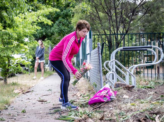 A community member lays flowers at the school on Tuesday. Picture: Jake Nowakowski