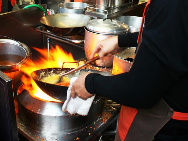 Cooks work at flaming woks on the footpath outside Pad Thai Thip Samai For Bankgkok Street Food featurePhoto: Gary Walsh Fee applies, single use, must credit