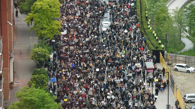 Demonstrators hold placards as they attend a protest march to the US Embassy in London. Picture: AFP