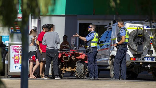 Police talk to youth on a quadbike at a service station in downtown Carnarvon. Picture: Jon Gellweiler/news.com.au